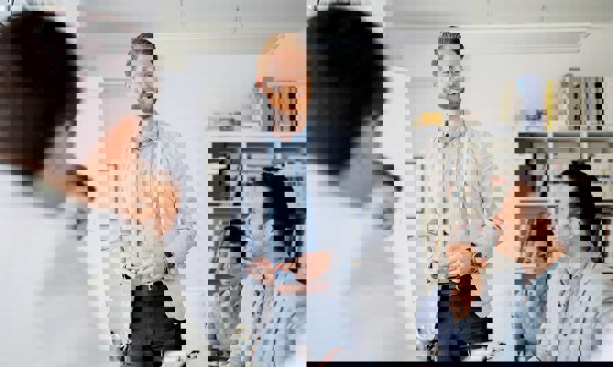 man stands in front of group smiling presenting with flipchart